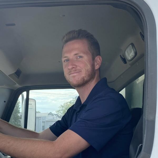 Big Bear Shredding driver, Joe, sitting in truck looking out the window toward the camera